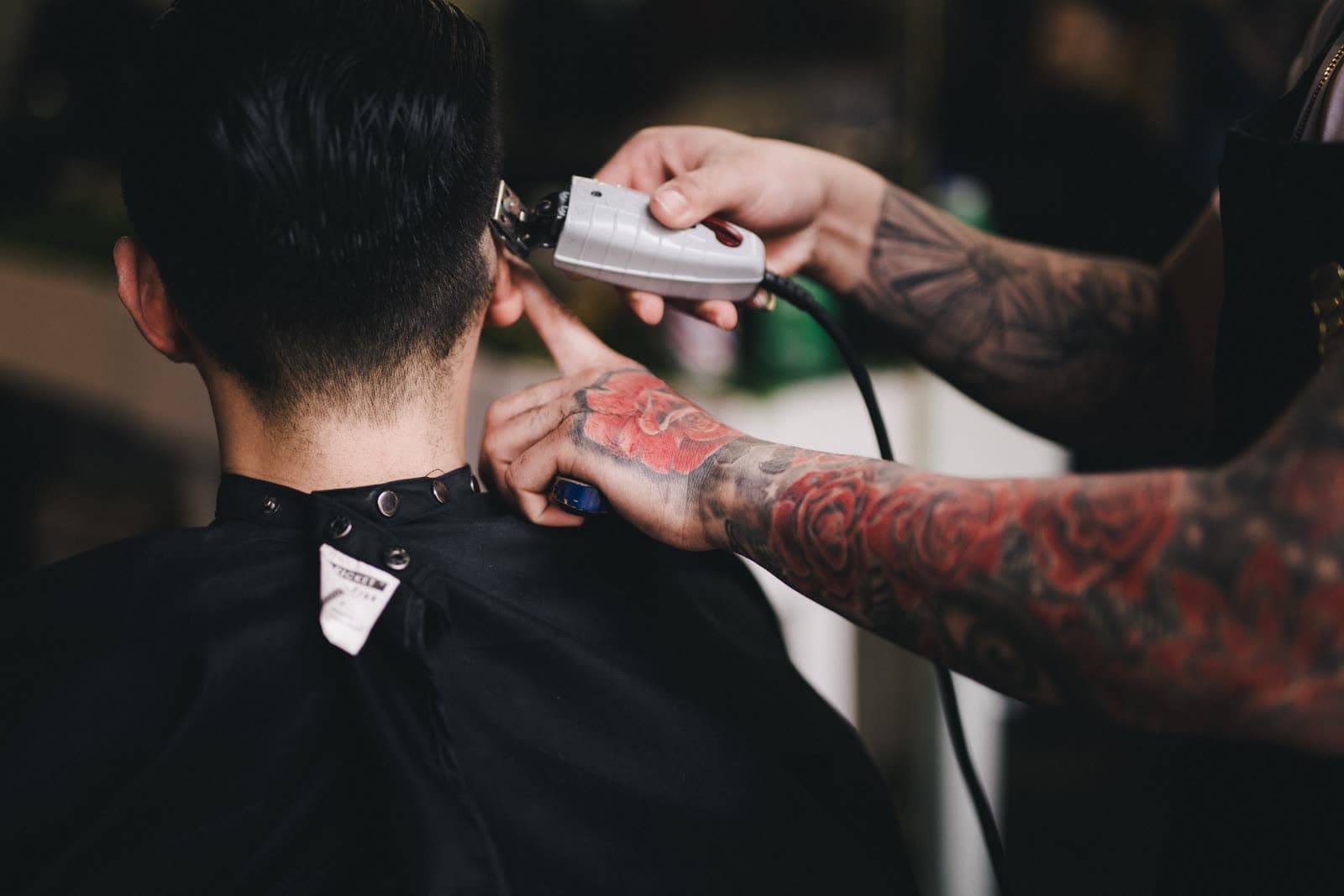 A barber finishing a client’s cut