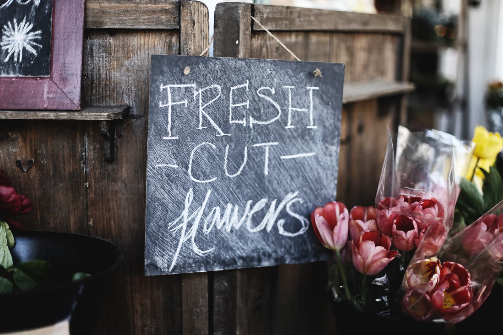 A hand-lettered "fresh cut flowers" sign at a florist